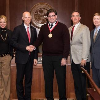 Gov. Rick Scott presenting the Governor’s Young Entrepreneur Award to James Stage